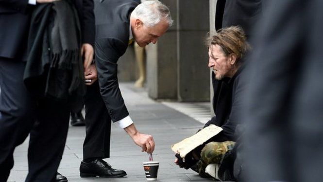 Ông Malcolm Turnbull cho tiền người ăn xin trên đường phố Melbourne hôm 18-8 - Ảnh: AAP
