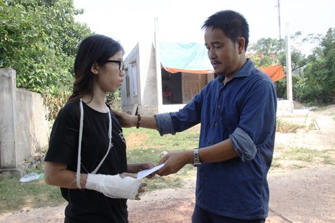 Đại diện báo Thanh Niên hỗ trợ tiền cho em Hồ Thị Thanh Nguyên chữa trị cánh tay bị rạn xương. ẢNH: NGUYỄN PHÚC